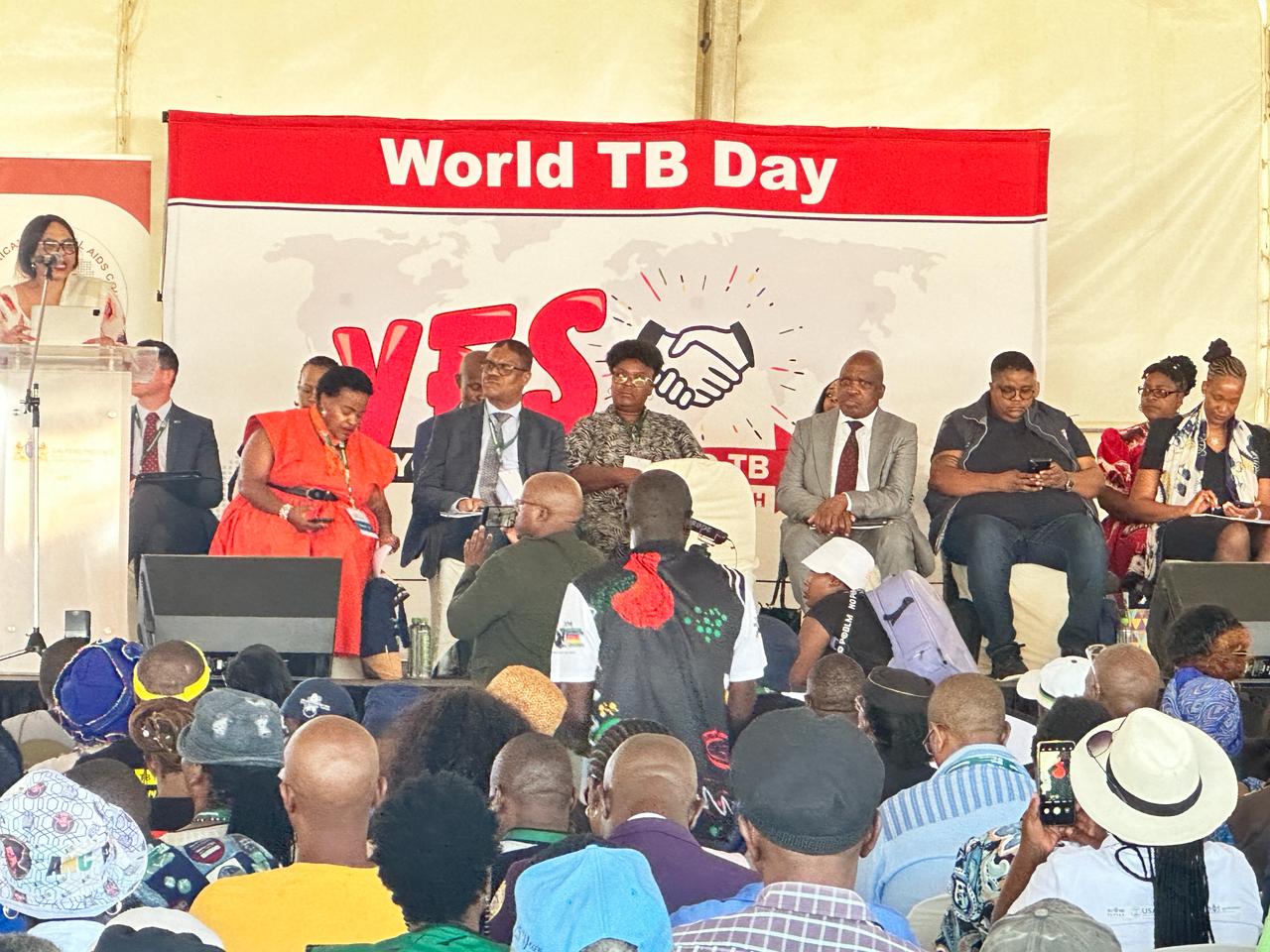 A World TB Day commemoration, with speakers on stage beneath a World TB Day banner